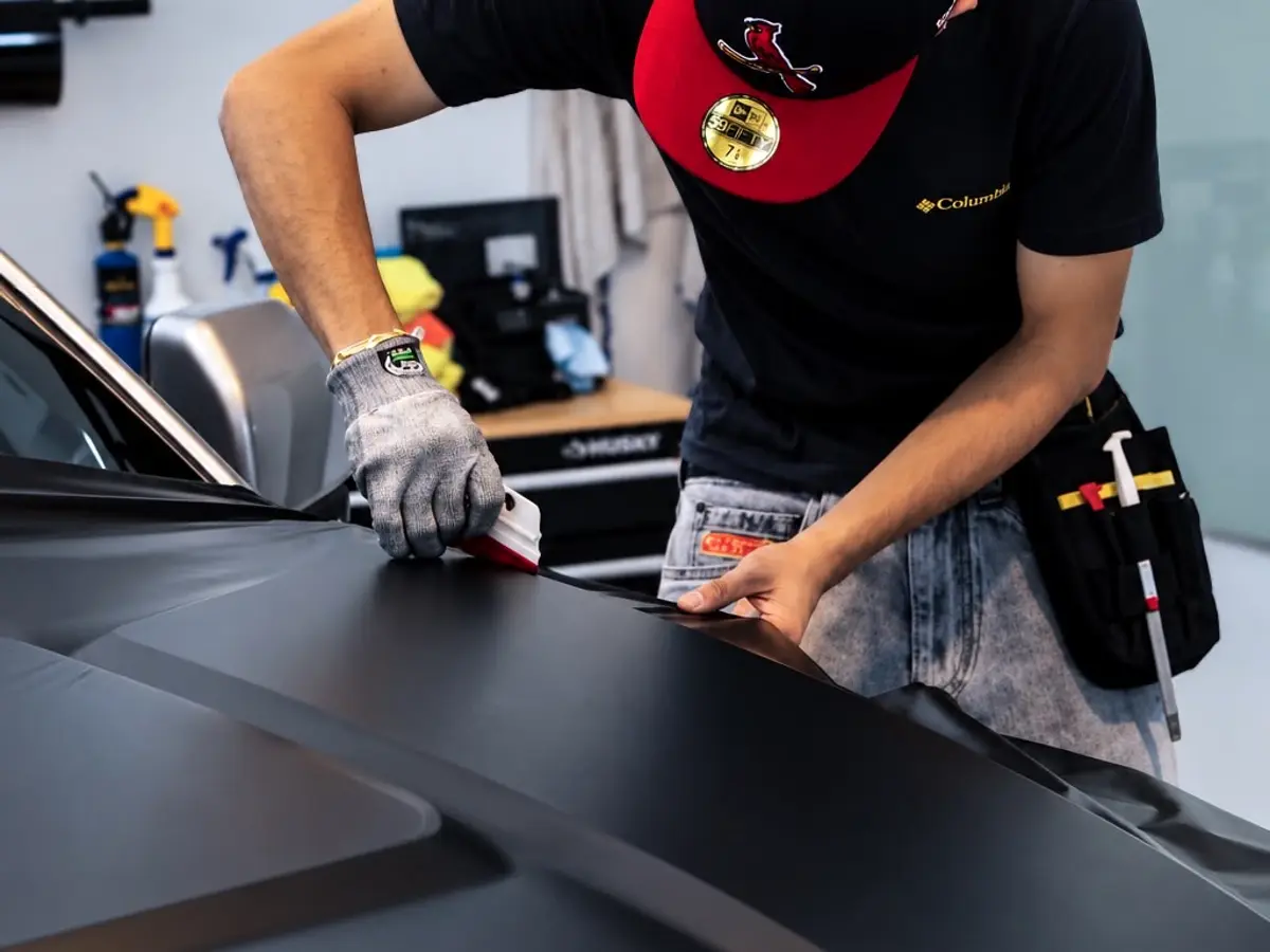 Irving carefully trimming wrap film on the Ford Raptor